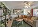 Cozy living room featuring a plush sofa, decorative plants, and a large mirror enhancing the bright and airy ambiance at 7055 Sylvan Oak Dr, Las Vegas, NV 89147
