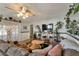 Comfortable living room with a large sofa, decorative plants, a ceiling fan, and ample natural light from the doors at 7055 Sylvan Oak Dr, Las Vegas, NV 89147
