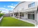 Spacious backyard includes artificial turf, an extended covered patio, and views of the home's exterior at 7307 Grace Estate Ave, Las Vegas, NV 89113