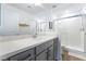 Modern bathroom with gray vanity, white countertop, and glass-enclosed shower stall at 7307 Grace Estate Ave, Las Vegas, NV 89113