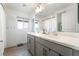 Bright bathroom featuring double sinks, a window, wood-look flooring, and modern fixtures at 7307 Grace Estate Ave, Las Vegas, NV 89113