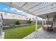 Covered patio provides shade, with views of the manicured backyard and landscaped retaining wall at 7307 Grace Estate Ave, Las Vegas, NV 89113