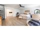 A serene main bedroom featuring light wood flooring, a ceiling fan, and neutral decor at 7307 Grace Estate Ave, Las Vegas, NV 89113