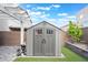 Charming storage shed in backyard, complemented by artificial turf and manicured landscape at 7307 Grace Estate Ave, Las Vegas, NV 89113