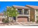 Inviting two-story home featuring a charming balcony, stone accents, and a well-manicured front yard at 7732 Canon Walk St, Las Vegas, NV 89139