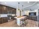 Modern kitchen with dark cabinets, stainless steel appliances, and a stylish island with seating at 7732 Canon Walk St, Las Vegas, NV 89139