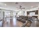 Open-concept living area featuring a large sectional sofa, dining space, and a modern kitchen at 7732 Canon Walk St, Las Vegas, NV 89139