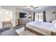 Comfortable bedroom features wood-look floors, a ceiling fan, and large picture windows overlooking the backyard at 7732 Canon Walk St, Las Vegas, NV 89139
