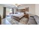 Bedroom with wood-look floors, a ceiling fan, and sliding doors to the back yard, plus a comfortable sofa at 7732 Canon Walk St, Las Vegas, NV 89139