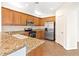 Kitchen with wood cabinets, granite countertops, stainless steel appliances, and tile flooring at 7941 Limestone Arch Ave, Las Vegas, NV 89178