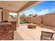 Covered patio with an outdoor kitchen area and a cozy fire pit for outdoor entertaining at 7941 Limestone Arch Ave, Las Vegas, NV 89178
