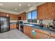 Well-lit kitchen with oak cabinets, black appliances, and a view of the backyard at 8421 Cheerful Brook Ave, Las Vegas, NV 89143