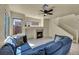 Spacious living room features a fireplace, ceiling fan, and a comfortable blue sectional sofa at 8421 Cheerful Brook Ave, Las Vegas, NV 89143