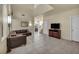 Open living room features tile floors, high ceilings, and a cozy brown leather sectional sofa at 8421 Cheerful Brook Ave, Las Vegas, NV 89143