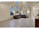 Bright living room boasts high ceilings, large windows, and a comfortable brown leather sectional sofa at 8421 Cheerful Brook Ave, Las Vegas, NV 89143