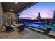 Inviting outdoor patio with a sparkling pool, stylish seating, and beautiful landscaping at twilight at 91 Alta Cascata Pl, Henderson, NV 89011