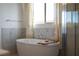 Soaking tub beside a walk-in shower with marble tile at 91 Alta Cascata Pl, Henderson, NV 89011