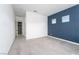 Spacious bedroom with neutral carpeting, blue accent wall, and access to an adjoining hallway at 91 Alta Cascata Pl, Henderson, NV 89011