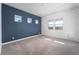 Bright, empty bedroom showcasing a blue accent wall and three symmetrically placed windows at 91 Alta Cascata Pl, Henderson, NV 89011