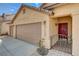 Warm-toned single-Gathering home with a three-car garage, desert landscaping, and gated front porch at 9530 Redstar St, Las Vegas, NV 89123
