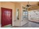Inviting front porch featuring a red door, tiled flooring, and a ceiling fan for warm weather at 9530 Redstar St, Las Vegas, NV 89123