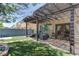 Private backyard featuring an outdoor living area, mature trees, and green turf at 9844 Red Horse St, Las Vegas, NV 89143