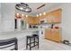 Bright kitchen features wood cabinetry, a breakfast bar with seating, stainless steel appliances, and modern lighting at 9844 Red Horse St, Las Vegas, NV 89143