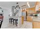 Open-concept kitchen includes a breakfast bar, wood cabinets, stainless steel appliances, and access to the staircase at 9844 Red Horse St, Las Vegas, NV 89143