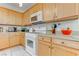 Close up on kitchen featuring wood cabinetry, light countertops, and white appliances at 9844 Red Horse St, Las Vegas, NV 89143