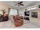 Relaxing living room featuring a ceiling fan, tile fireplace and large picture windows at 9844 Red Horse St, Las Vegas, NV 89143