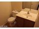 Cozy half bathroom with a vanity cabinet, sink, and toilet at 10021 Via Toro Ave, Las Vegas, NV 89117