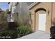 Inviting front entrance to home with neutral stucco, manicured bushes, and a covered entryway at 10021 Via Toro Ave, Las Vegas, NV 89117