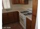 Functional kitchen with oak cabinets, tile countertop, and white appliances at 10021 Via Toro Ave, Las Vegas, NV 89117