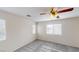 Spacious bedroom with plush carpeting, two windows providing ample natural light, and a ceiling fan at 10245 Missouri Meadows St, Las Vegas, NV 89183