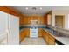 Functional kitchen with wooden cabinets, tile flooring, and modern white appliances at 10245 Missouri Meadows St, Las Vegas, NV 89183
