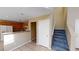 Open kitchen next to carpeted stairs, cabinets, white fridge, and tile flooring at 10245 Missouri Meadows St, Las Vegas, NV 89183