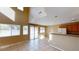 Open-concept living room with breakfast bar, tile floors, large windows, and a sliding glass door at 10245 Missouri Meadows St, Las Vegas, NV 89183