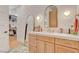 Bathroom featuring a light wood vanity, arched mirror and a closet at 10969 Tranquil Waters Ct, Las Vegas, NV 89135