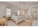 Charming bedroom with a white bed, neutral colored rug, and seating area at 10969 Tranquil Waters Ct, Las Vegas, NV 89135