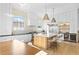 Well-lit kitchen with white cabinets, stainless steel appliances, large island, and hardwood floors at 10969 Tranquil Waters Ct, Las Vegas, NV 89135