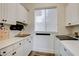 Bright laundry room features white cabinets, a modern washer and dryer, and neutral paint at 10969 Tranquil Waters Ct, Las Vegas, NV 89135
