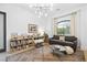 Bright living room features hardwood floors, a modern light fixture, a window view, and a gray sofa at 10969 Tranquil Waters Ct, Las Vegas, NV 89135