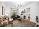 Living room features a modern light fixture, hardwood floors, and a small bar at 10969 Tranquil Waters Ct, Las Vegas, NV 89135