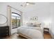 Primary bedroom featuring natural light, neutral paint, hardwood floors, and blackout curtains at 10969 Tranquil Waters Ct, Las Vegas, NV 89135
