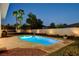 Backyard featuring a sparkling pool, palm trees, green lawn, and ample space for relaxation at 10969 Tranquil Waters Ct, Las Vegas, NV 89135