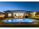Inviting backyard with a refreshing pool, manicured lawn, and an inviting covered patio at 10969 Tranquil Waters Ct, Las Vegas, NV 89135