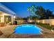 Charming backyard featuring a lit swimming pool, green lawn, and outdoor dining space at 10969 Tranquil Waters Ct, Las Vegas, NV 89135