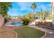 Backyard with a sparkling pool, spa, and outdoor kitchen, perfect for entertaining and enjoying the outdoors at 10993 Ladyburn Ct, Las Vegas, NV 89141