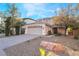 Lovely home with an attached garage, mature trees, desert landscaping, and a brick driveway at 10993 Ladyburn Ct, Las Vegas, NV 89141