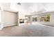 Spacious living room with a fireplace, a tray ceiling, large windows, and carpet flooring at 10993 Ladyburn Ct, Las Vegas, NV 89141